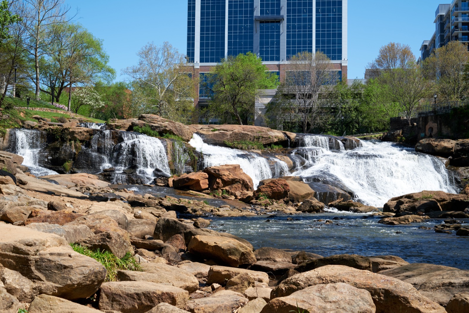 Waterfalls and downtown buildings at Falls Park in Greenville, South Carolina